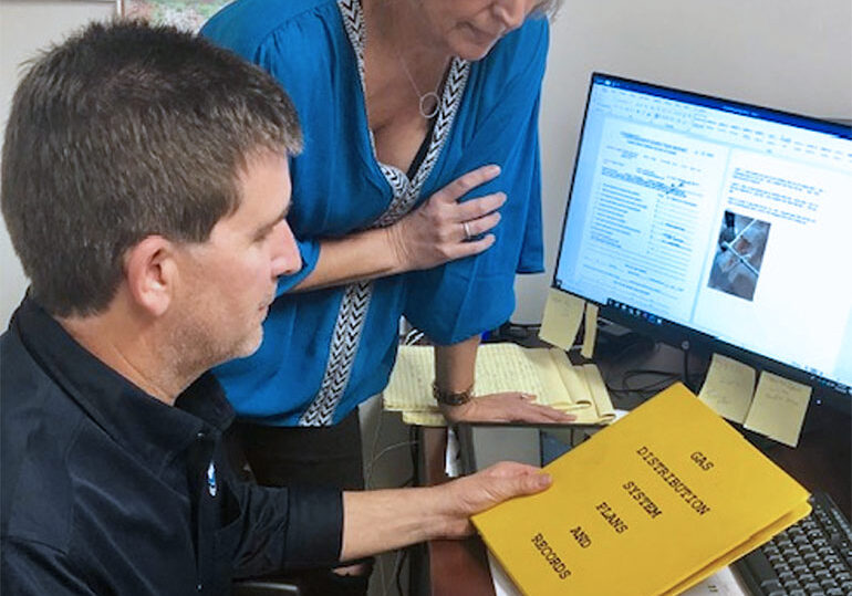 photo of a woman and man reviewing pipeline inspection services manuals and plans